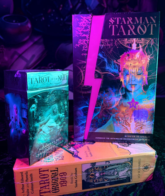 Colorful display of tarot decks including Starman Tarot, Tarot de la Nuit, and Tarot Original 1909 on a mystical velvet cloth background — beginner and collector tarot card decks for divination and spiritual readings