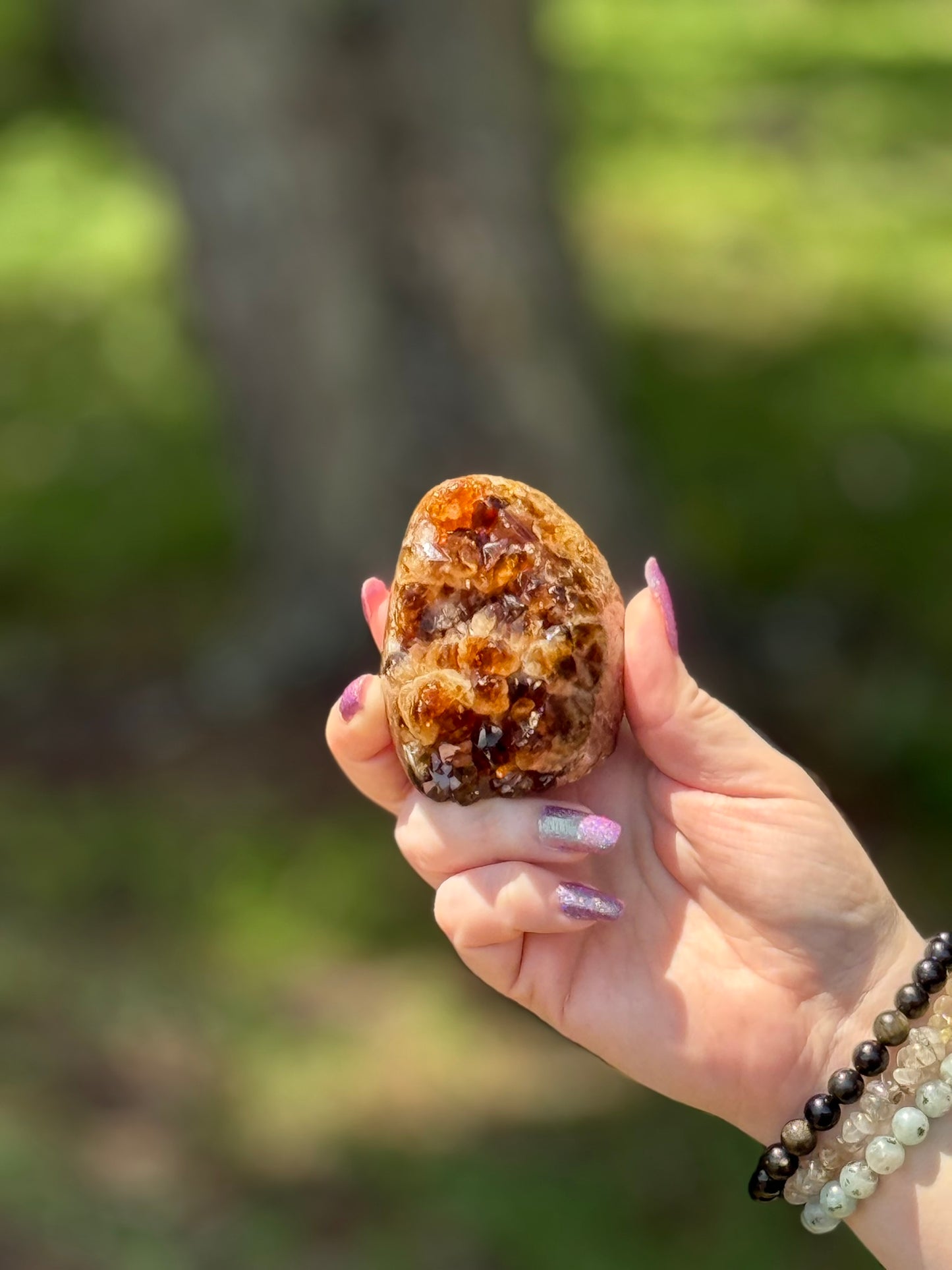 Golden honey-toned cut base citrine crystal cluster shown in hand, polished with raw top formation