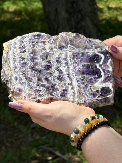 Front-facing view of a dreamy chevron amethyst slab displaying bold V-shaped quartz banding, ideal for spiritual healing and third eye activation.
