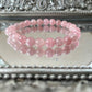 Handmade Rose Quartz bracelet with polished pink crystal beads displayed on an ornate mirrored surface, ideal for heart chakra healing and self-love energy