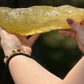 Side profile of a large translucent citrine slab glowing in natural sunlight, emphasizing its elongated free-form shape and deep golden tone.
