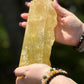 Front view of a natural citrine slab held in hand, showing golden-yellow clarity and polished finish under daylight.